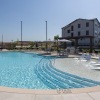 a pool with lounge chairs around it and a building in the background