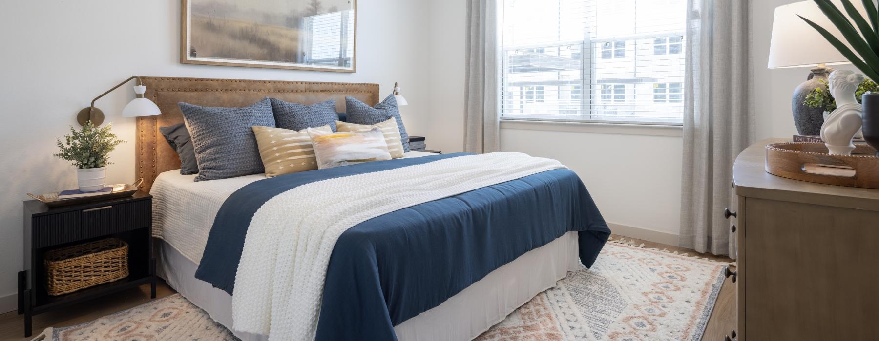 a bedroom with a bed and a fan and a window