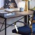 a desk with a chair and a painting on the wall