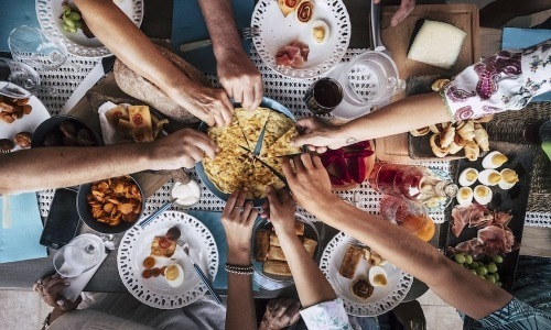 Dining people reaching for pizza
