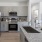 a kitchen with grey cabinets and marble countertops