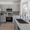 a kitchen with grey cabinets and marble countertops